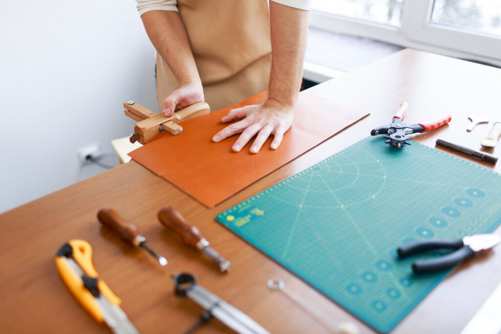 Leathercraftsman measuring workpiece at work